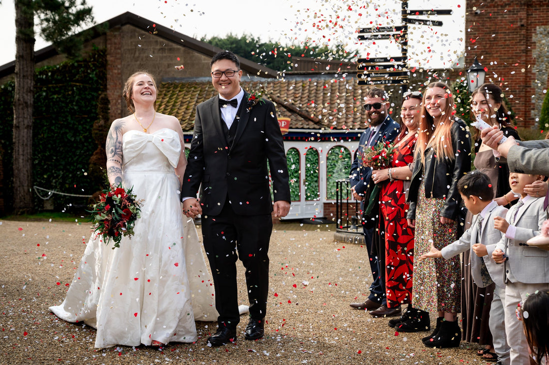 A couple being showered on by paper Confetti from a Confetti cannon 