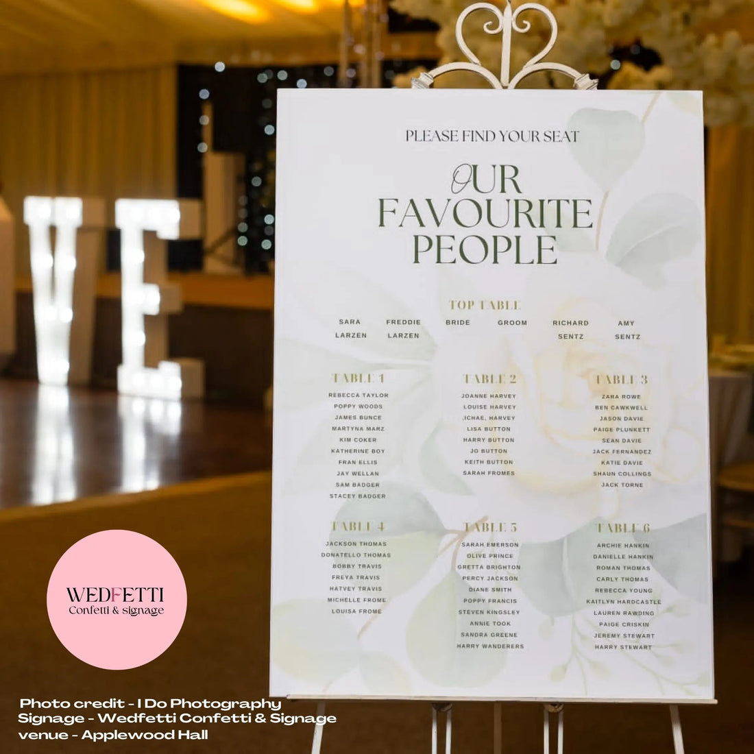A seating plan displayed on an easel in a wedding style setting, in a sage green design 