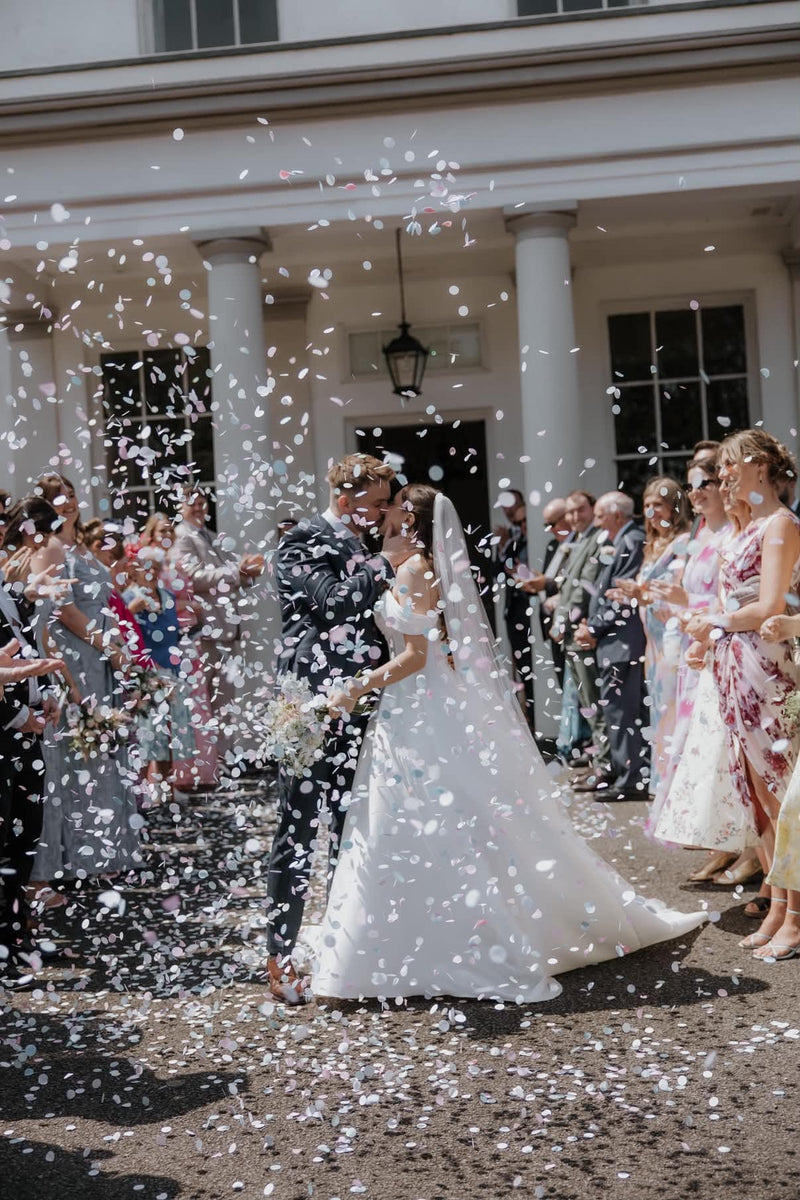A couple being showered with Biodegradable paper Confetti