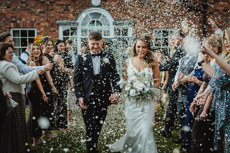 A couple being showered with Biodegradable paper Confetti