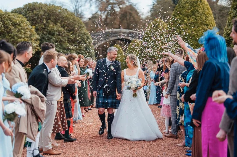 A couple being showered with Biodegradable paper Confetti