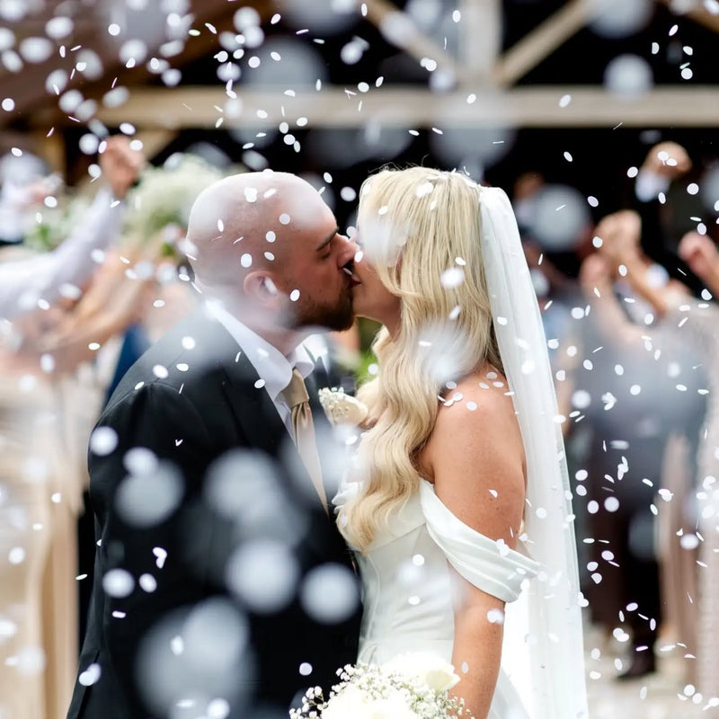 A close up image of a couple b showered with Biodegradable paper Confetti at a wedding