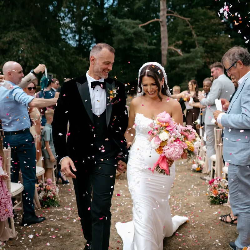 A couple being showered with real Petal Confetti